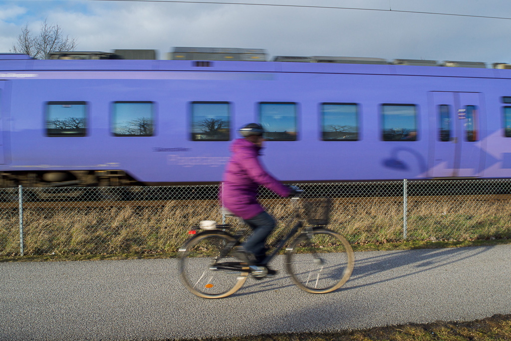 Cyklist och tåg i bakgrunden. Framgångsrik med tidiga morgonvanor.
